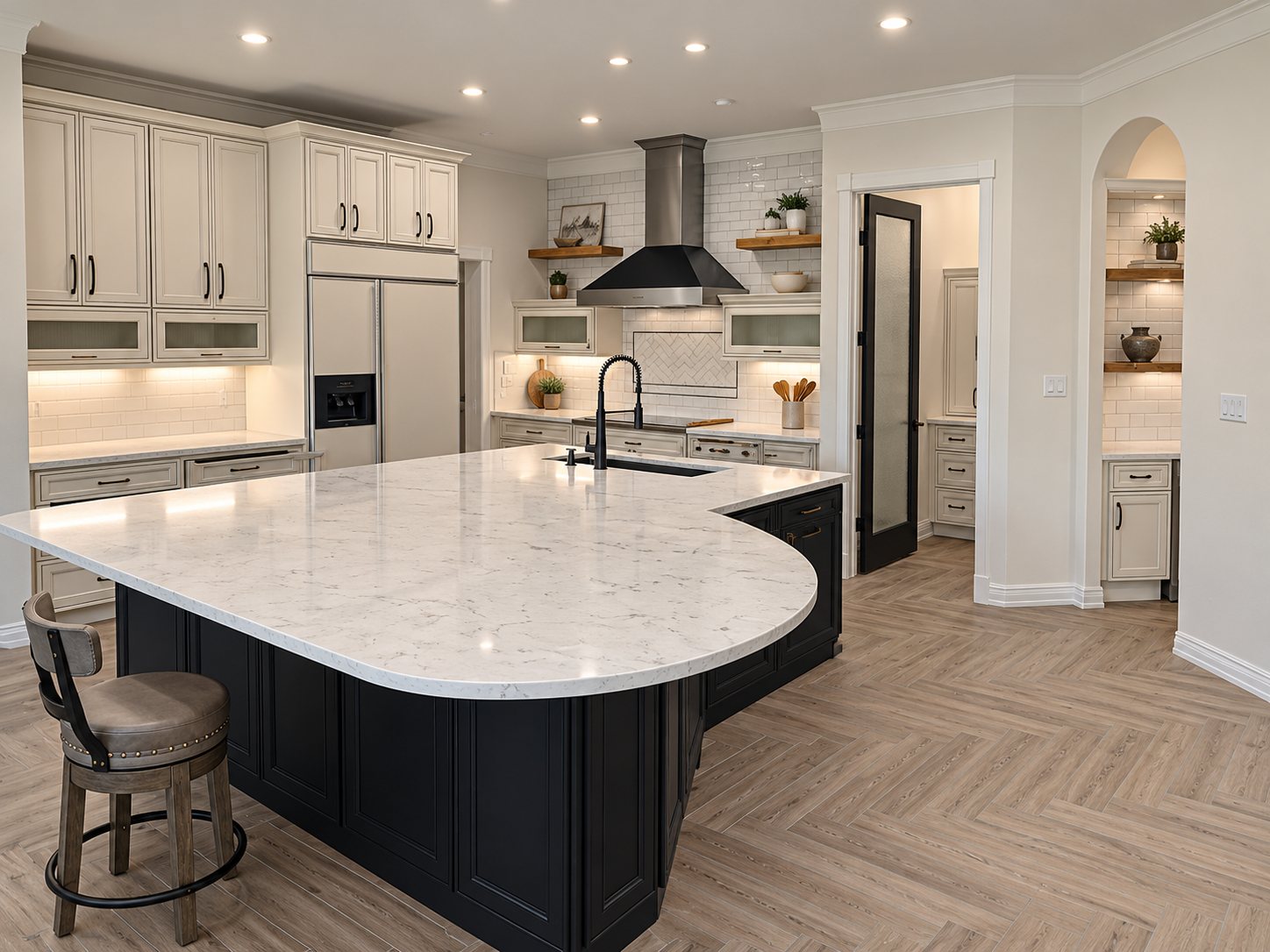 Cream cabinets, charcoal island and light herringbone kitchen flooring